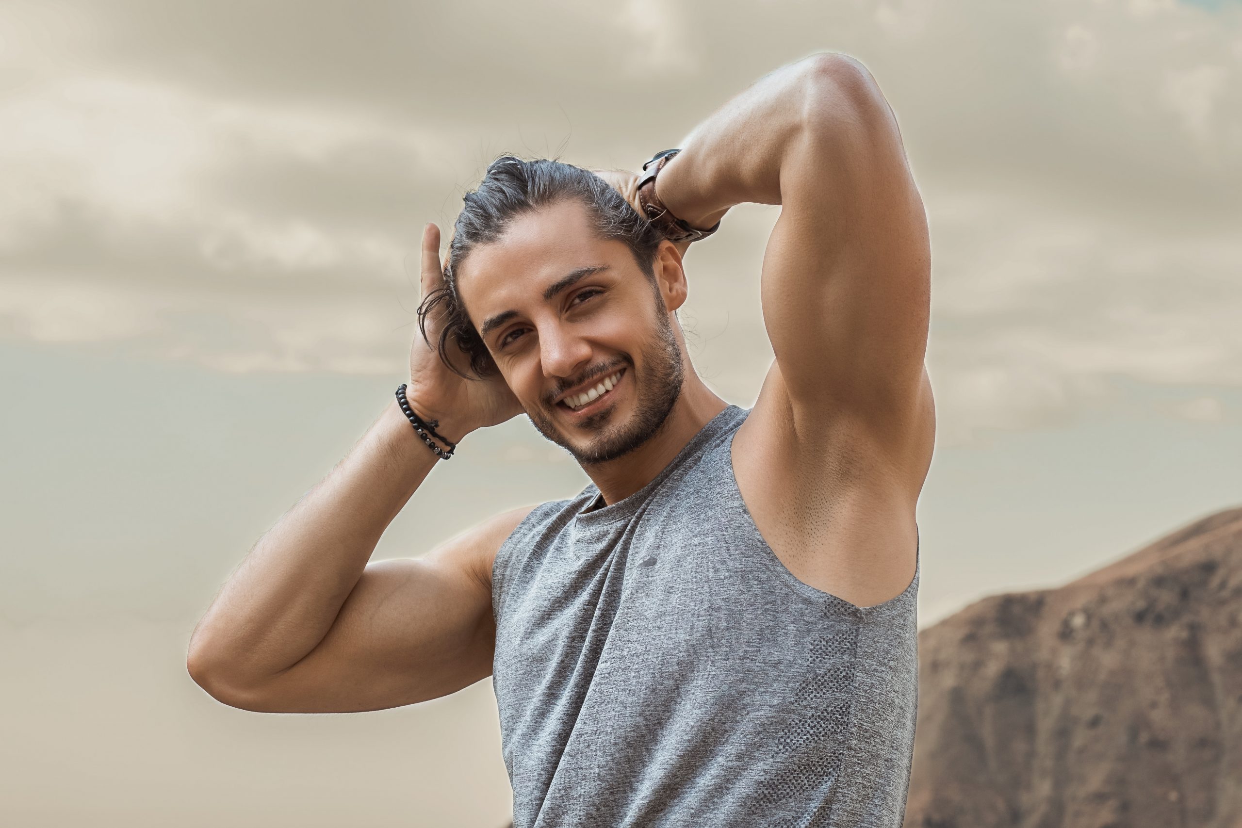man in gray tank top smiling