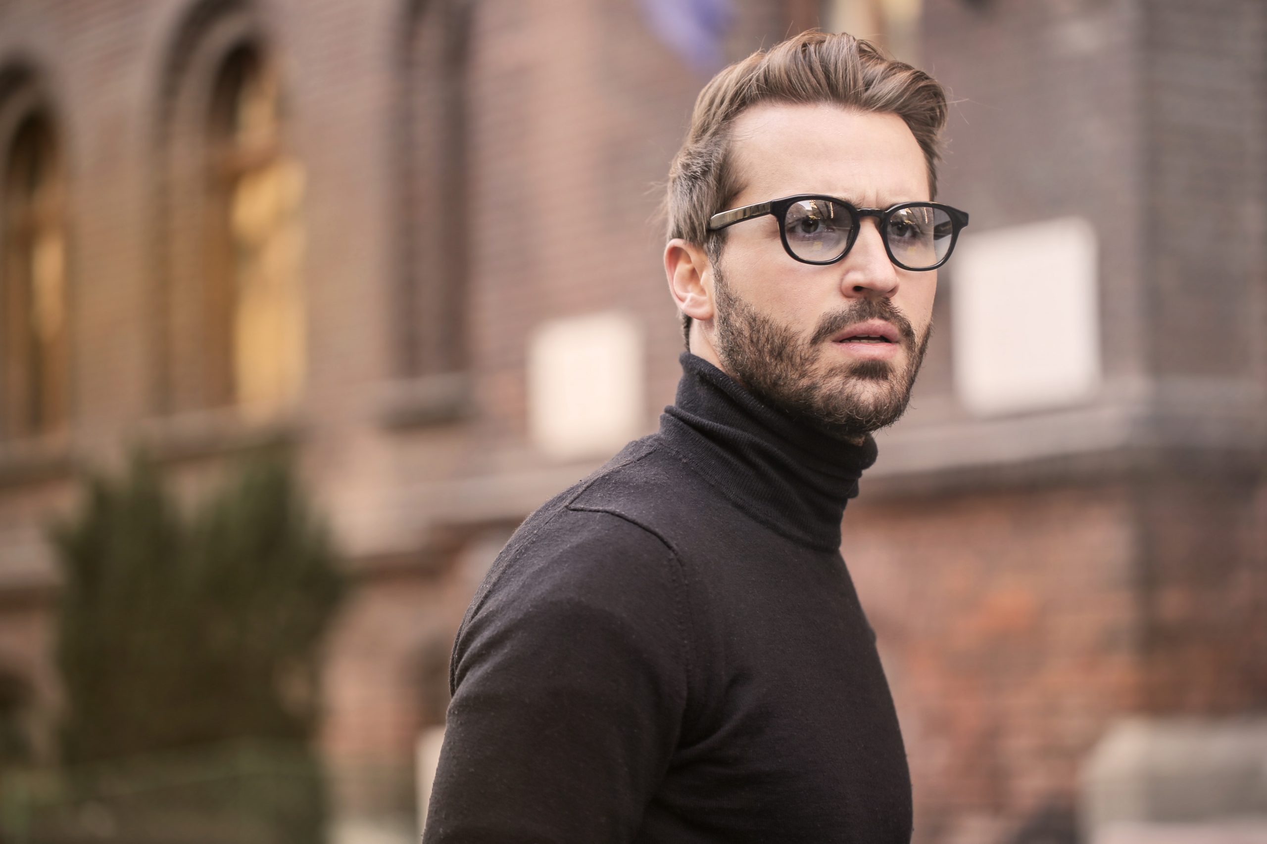 Man standing near building white black turtleneck shirt